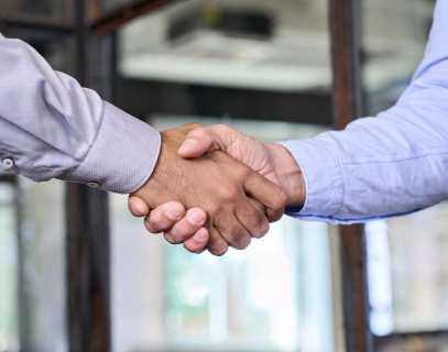 Close-up of a firm handshake between two business individuals, representing trust and partnership.