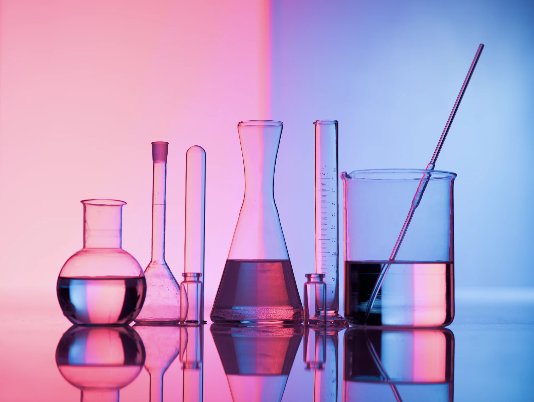 Laboratory glassware with colored solutions, representing our work in chemical research and innovation.